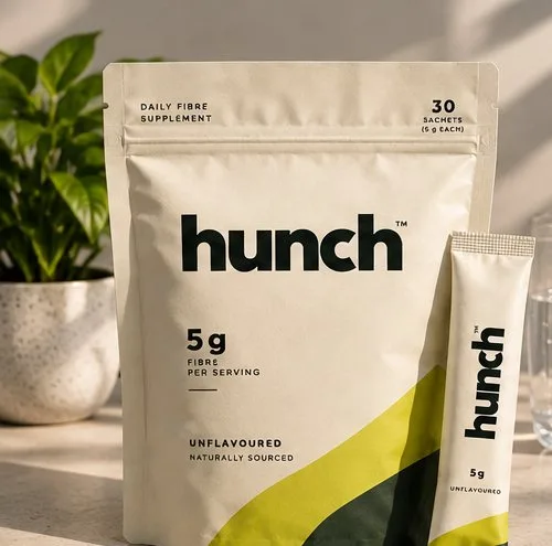 hunch fiber pouch and stick pack on a table with a plant and water glass